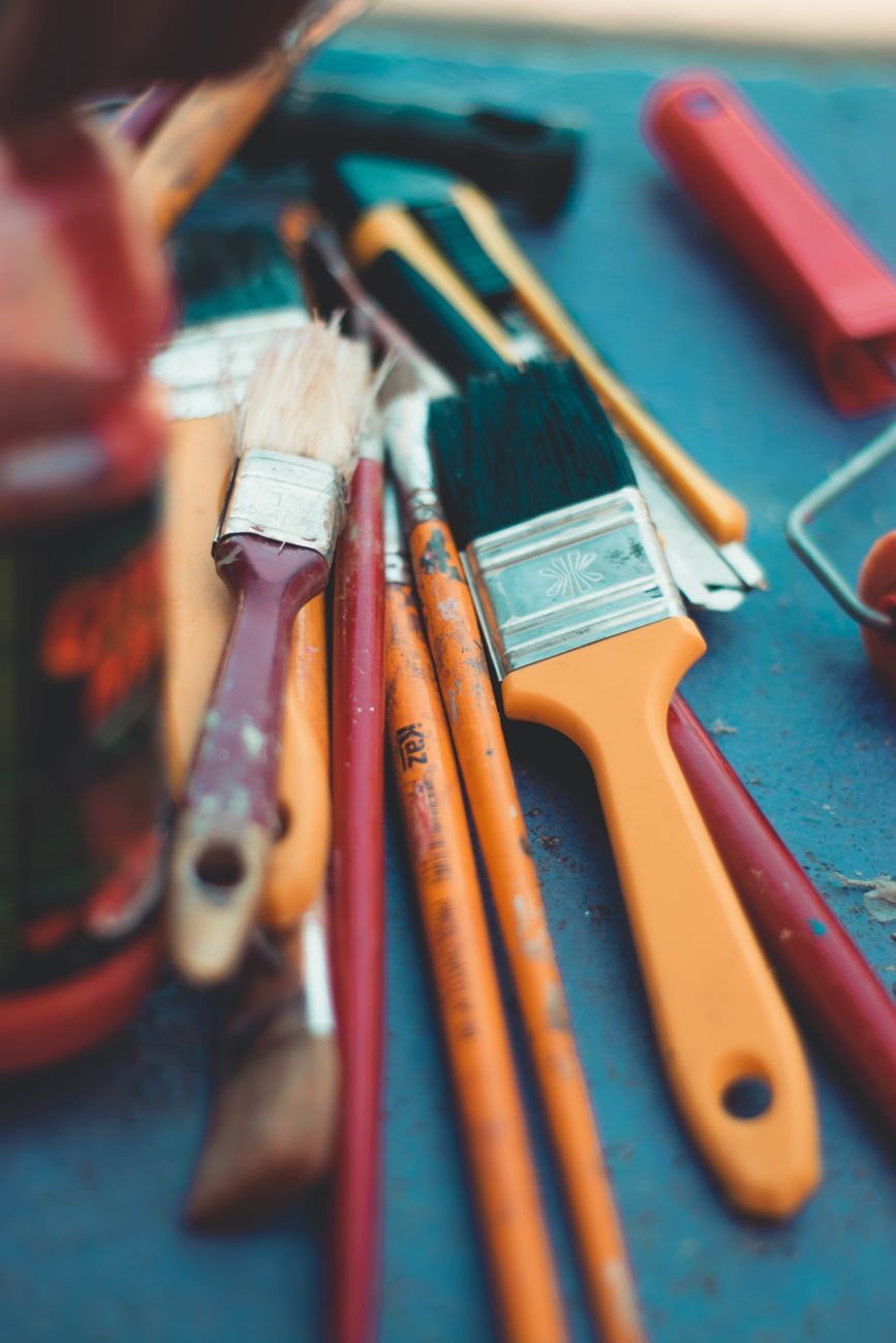 Various paintbrushes on a blue surface, perfect for art or DIY projects.